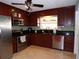 Kitchen with dark wood cabinets, stainless steel appliances, and granite countertops at 4131 Yorketowne Rd, Orlando, FL 32812