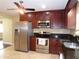 Kitchen featuring stainless steel appliances, granite countertops, and cherry cabinets at 4131 Yorketowne Rd, Orlando, FL 32812