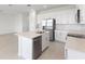 Open kitchen with stainless appliances, island, and view into the living space at 507 Silver Palm Dr, Haines City, FL 33844