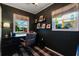 Dark-walled home office with built-in shelving and a large desk at 512 E Gore St, Orlando, FL 32806