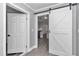 Hallway features an interior door, slider barn door, and views of the kitchen at 520 Sw 38Th St, Ocala, FL 34471