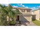 Two-story house with tan siding, brown door, and a two-car garage at 5317 Jubiloso Dr, St Cloud, FL 34771