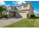 Two-story house with tan siding, brown door, and a two-car garage at 5317 Jubiloso Dr, St Cloud, FL 34771