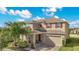 Two-story house with tan siding, brown door, and a two-car garage at 5317 Jubiloso Dr, St Cloud, FL 34771