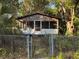 Home with chain link fence, needs TLC, surrounded by lush vegetation at 641 W Beresford Rd, Deland, FL 32720