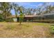 Large backyard with screened patio and open grassy area at 8045 Happy Trl, Kissimmee, FL 34747