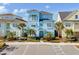 Two-story light blue house with a walkway, landscaping, and palm trees at 8153 Surf St, Kissimmee, FL 34747