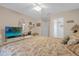 Spacious bedroom with a floral comforter and a large TV at 8511 La Isla Dr, Kissimmee, FL 34747