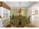 Dining room with a table for six, chandelier, and green walls at 8511 La Isla Dr, Kissimmee, FL 34747