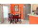 Small dining area with four chairs and an orange accent wall at 8515 Sunrise Key Dr, Kissimmee, FL 34747