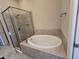 Bathroom with soaking tub and glass-enclosed shower at 9121 Laureate Blvd, Orlando, FL 32827