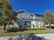 Rear view of two-story home with pergola and landscaping at 9121 Laureate Blvd, Orlando, FL 32827