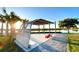 Relaxing lakeside pavilion with wooden pergola and red Adirondack chairs at 9121 Laureate Blvd, Orlando, FL 32827