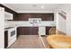 Kitchen with dark brown cabinets, white appliances, and a breakfast nook at 942 Beresford Way, Lake Mary, FL 32746