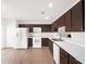 Kitchen with dark brown cabinets, white appliances, and tile floor at 942 Beresford Way, Lake Mary, FL 32746