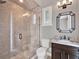 Bathroom with a walk-in shower, toilet, and dark wood vanity at 9512 Tavistock Rd, Orlando, FL 32827