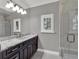 Modern bathroom with a walk-in shower and granite vanity at 9512 Tavistock Rd, Orlando, FL 32827