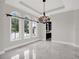 Bright dining room with chandelier and three arched windows at 9512 Tavistock Rd, Orlando, FL 32827