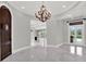 Bright entryway with chandelier, high ceilings, and views to other rooms at 9512 Tavistock Rd, Orlando, FL 32827