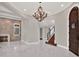 Elegant entryway with arched doorway, chandelier, and hardwood stairs at 9512 Tavistock Rd, Orlando, FL 32827