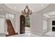 Elegant entryway with arched doorway, chandelier, and hardwood stairs at 9512 Tavistock Rd, Orlando, FL 32827