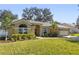 Tan one story house with a gray roof, two car garage and landscaped yard at 960 Manchester Ave, Oviedo, FL 32765