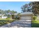 Tan one-story house with gray roof, two-car garage, and manicured lawn at 960 Manchester Ave, Oviedo, FL 32765