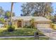 Tan one-story house with gray roof, two-car garage, and manicured lawn at 960 Manchester Ave, Oviedo, FL 32765