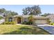 Tan one-story house with gray roof, two-car garage, and landscaped yard at 960 Manchester Ave, Oviedo, FL 32765