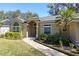 Tan one-story house with gray roof, two-car garage, and manicured lawn at 960 Manchester Ave, Oviedo, FL 32765