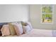 Cozy bedroom featuring a bed with decorative pillows and a window with a view of trees at 10060 Pecan Hickory Way, Orlando, FL 32832