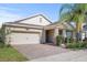Charming single-Gathering home featuring a brick-paved driveway and manicured landscaping at 10060 Pecan Hickory Way, Orlando, FL 32832