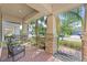 Inviting front porch with brick columns and two black metal chairs at 10060 Pecan Hickory Way, Orlando, FL 32832