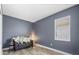 Cozy living room with dark blue walls, comfortable seating, and bright window at 10060 Pecan Hickory Way, Orlando, FL 32832
