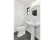 Clean bathroom with pedestal sink, toilet, and dark gray tile floor at 1025 Early Ave, Winter Park, FL 32789