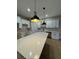Bright, modern kitchen featuring white cabinets, stone countertops, and stylish pendant lighting at 116 E Cleveland St, Apopka, FL 32703
