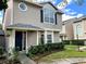 Tan two-story home with a black door and landscaping at 12107 Bruceton Way # 102, Orlando, FL 32828