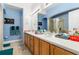 Bathroom with double vanity, framed mirrors, and bright blue walls at 1211 Stonecutter Dr # 206, Celebration, FL 34747
