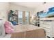 Bright bedroom featuring a white bed, a shelf full of toys and decor, and large windows for ample sunlight at 1211 Stonecutter Dr # 206, Celebration, FL 34747