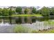Scenic view of a multi-story building reflecting on a calm lake, surrounded by lush greenery at 1211 Stonecutter Dr # 206, Celebration, FL 34747