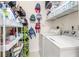 Efficient laundry room featuring white washer and dryer, overhead shelving and organization system at 1211 Stonecutter Dr # 206, Celebration, FL 34747