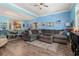Open-concept living room features hardwood flooring, an inviting sectional sofa, and an open view to the kitchen and dining area at 1211 Stonecutter Dr # 206, Celebration, FL 34747