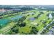 Aerial view of a golf course community with a lake and cityscape in the background at 1211 Stonecutter Dr # 206, Kissimmee, FL 34747