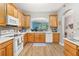 Kitchen with light wood cabinets, white appliances, and a view to the dining room at 1211 Stonecutter Dr # 206, Celebration, FL 34747