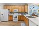 Kitchen boasts light wood cabinets, white appliances, and ample counter space at 1211 Stonecutter Dr # 206, Celebration, FL 34747