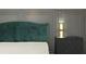 Closeup of the main bedroom with a green velvet headboard and nightstand at 12754 Brodlove Ln, Winter Garden, FL 34787