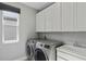 Bright laundry room with washer, dryer, and ample cabinets at 12754 Brodlove Ln, Winter Garden, FL 34787