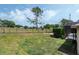 Large backyard with green grass, mature trees, and a black metal fence, perfect for outdoor activities at 14101 Vista Del Lago Blvd, Clermont, FL 34711