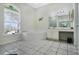 Large bathroom with a jetted tub under an arched window and a vanity at 14101 Vista Del Lago Blvd, Clermont, FL 34711