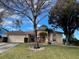 Tan one-story house with a two-car garage and landscaped yard at 14101 Vista Del Lago Blvd, Clermont, FL 34711